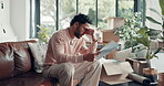 Stress, documents and mortgage with man on sofa for home loan rejection, foreclosure and risk. Debt letter, eviction notice and frustrated with person in living room of apartment for paperwork