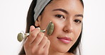 Skincare, face roller and woman in studio for natural, beauty or facial glow with massage. Health, wellness and person with cosmetic tool for lymphatic drainage with dermatology by white background.