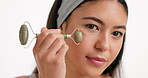 Beauty, face roller and woman in studio for natural, skincare or facial glow with massage. Health, wellness and person with cosmetic tool for lymphatic drainage with dermatology by white background.