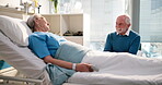 Healthcare, laughing and old woman in hospital with husband for recovery from operation. Funny, medical and support with senior couple in clinic together for rehabilitation, treatment or wellness