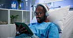 Headphones, hospital and patient with tablet in bed for recovery, streaming movie or online series. IV drip, happy black man and tech in clinic for watching film, listening to video audio and healing