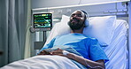 Healthcare, hospital and patient with headphones in bed for recovery, music and healing podcast. Smile, black man and listening to audio playlist in inpatient clinic for resting and medical wellness