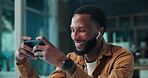 Laughing, man and watching videos on smartphone, office and listen to sound with earphones or audio. Happy, employee and black person on break with mobile, entertainment and funny movies or comedy