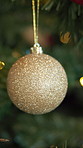 Christmas, tree and gold bauble for decoration, festive season and party celebration in house. Holiday, xmas and ornament with shine for December tradition, bokeh and glitter for new year event