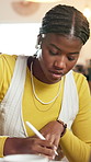 Woman, earphones and student writing at house for streaming podcast, studying and learning notes. Female person, listening to music or laptop for research, university schedule and assignment reminder
