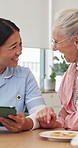 Senior woman, nurse and tablet in home with conversation, funny joke or medical results at lunch. Healthcare, elderly person or caregiver laughing with tech in assisted living for health news or chat