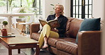 Reading, relax and thinking with woman on sofa in living room of home for hobby or retirement. Book, fantasy literature and story with mature person in apartment for break, me time or wellness