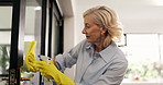 Cleaning, window and mature woman with spray bottle for hygiene, disinfection and housekeeping. Housework, home and person with gloves, detergents and washing glass for dirt, shine and bacteria