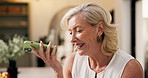 Mature, happy woman and phone with speaker in home for communication, chat or conversation. Female person, talking and mobile smartphone with loudspeaker for audio message or voice note app in house