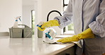 Hands, cleaning and person spray kitchen counter for hygiene maintenance, housework or chores. Bottle, gloves and wipe table in home with cloth for disinfection, bacteria safety and house sanitation
