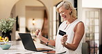 Mature, happy woman and home with credit card on laptop for online shopping or remote banking app. Female person, shopper or virtual payment with debit on computer for ecommerce or purchase success