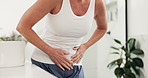 Hands, mature woman and stomach ache in home, menopause and health problem in bathroom. Constipation, discomfort and person with pain, abdomen cramps and sick with diarrhea in morning in house