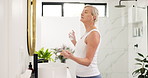 Mature woman, spray and perfume in bathroom for getting ready, fresh smell and grooming routine. Female person, mirror and cosmetic fragrance for hygiene, parfum application and liquid aroma at house