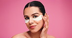 Eye patches, face and skincare with woman in studio for aesthetic, glow or skin hydration. Cosmetics, model and gel pad for dermatology with self care, beauty or collagen treatment on pink background