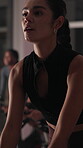Bike, workout and woman in gym, sweating and night with wellness, training and challenge. Healthy people, endurance and machine in fitness club, exercise and breathing with equipment and cycling