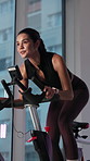 Sweat, spin class and woman on bike in gym for exercise, cardio workout and cycling for wellness. Fitness club, health and person on stationary machine for muscle strength, endurance and training