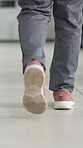 Back, shoes and person in clinic, doctor and healthcare with movement in hallway. Closeup, employee or professional in hospital, walking or feet with medical service, surgery prep or surgeon in lobby