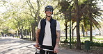 Happy man, face or delivery with bicycle in park for travel, commute or outdoor transportation. Portrait, male person or smile with helmet, bike or backpack for eco friendly courier service in nature