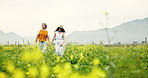 Walking, love and couple in field of flowers with bonding, care and romance on countryside holiday. Holding hands, relationship and man with woman in nature on rapeseed farm on weekend trip together.