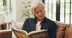 Reading, book and senior woman in home, think and relax with fiction on weekend, knowledge or novel. Calm, reader and old person with literature for entertainment, reflection and retirement in house