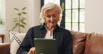 Reading, break and old woman with tablet, lounge or chill on couch, online and entertainment in home. Browsing, ebook and senior person with smile for funny novel, retirement and laugh with tech