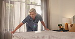 Woman, bedding and cleaning bed in home for morning routine, tidy bedroom and cleanliness. Wake up, mature person and fix blanket in apartment for housekeeping maintenance, domestic chores and habit