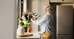 Arrangement, bouquet or elderly woman in home with smile, aesthetic or maintenance of green decoration. Sorting, happy or old person in kitchen with plant, clean air or floral display in house care.