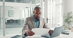Reading, paperwork and man with laptop, office and typing financial analysis on website or statement. Serious, accountant and black person with document, review and info for business records or tech