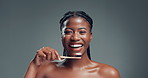 Oral health, toothbrush and face of black woman in studio with routine for fresh breath. Happy, toothpaste and portrait of African person brushing teeth for dental care and hygiene by gray background
