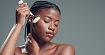 Black woman, jade roller and beauty in studio with self care, mock up space and circulation on background. African girl, model and skincare routine, dermatology and massage for lymphatic drainage