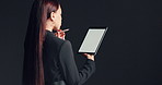Woman, lawyer and thinking in studio with tablet screen for court case on a dark background. Back view, female person or thoughtful attorney with technology display or mockup space for legal process