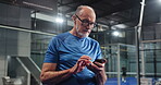 Typing, coach or elderly man in club with phone, scroll or message update during training break. Digital, sport or old person in court with mobile, tournament results or tennis tips on social media.