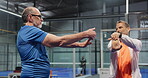 Man, stretching and instructor for padel at court for fitness, getting ready and instruction for course. Mature person, coach and warm up for sports lesson, training support and guidance of challenge