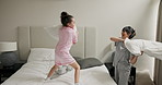 Bedroom, mother and pillow fight with child for game, laugh and bonding with girl in morning. Mom, kid and play with cushion in family home on bed with energy, funny or excited with foster parent