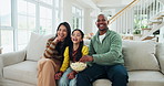 Popcorn, watching tv and parents laugh with child in home for comedy movie, show or film. Television, mother and father with kid, food or interracial family streaming funny series together in lounge