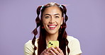 Face, girl and happy with phone in studio for social media browsing, status update or app download. Mockup space, gen z person or smile with smartphone on purple background for texting or online news