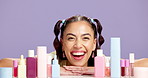 Woman face, skincare or product range in studio for  dermatology, makeup or morning routine. Beauty, confident or female person with cosmetic selection, facial treatment or smile on purple background