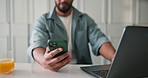 Man, hands and phone with laptop in home for network, online service or internet connectivity. Male person, user or remote work with mobile smartphone or computer for app, schedule or data sync