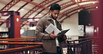 Man, research and reading in library with book, study and learning for university assignment. Student, person or literature in school with textbook, education or knowledge for college paper.