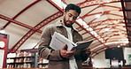 Books, university and man in library for education, learning or research with knowledge. Studying, project and male student with academic information for college exam, project or assignment on campus