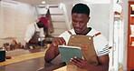 Typing, reading and black man at restaurant with tablet, menu development and plan for small business. Research food trend, tech and entrepreneur in kitchen, recipe creation and culinary innovation.