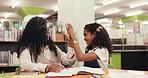 Book, teacher and high five with child for learning, support and development in school library. Girl, happy student and success with educator for education achievement, well done or talk for teaching