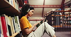 Education, book and woman with headphones, library or reading literature for exam, serious and study. Learning, university student and person with tech to block distractions, fiction and knowledge