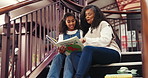 Book, library and grandmother reading with kid for bonding, connection or development. Happy, education and senior woman with girl child for story together on stairs for knowledge and learning.