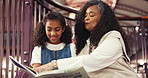 Book, library and grandma reading with child for bonding, connection or development. Happy, education and senior woman with girl kid for story together on stairs for knowledge and literature learning