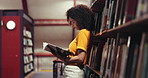 Woman, student and reading with book in library for choice, knowledge or literature in bookstore. Female person, academic or learning with information, insight or novel for study, story or education