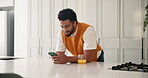 Phone, smile and reading with man in kitchen for orange juice recipe, social media and wellness blog. Communication, health drink search and connection with person in home for chat and update