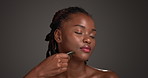Black woman, massage or skincare with gua sha in studio for anti aging on a gray background. Female person, African model or relax with space or beauty tool for facial treatment or lymphatic drainage