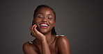 Face, happy and skincare with black woman in studio for dermatology, glow and self care. Beauty, shine and smooth skin with female person on dark background for space,  cosmetology and smile