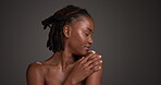 Shoulder, skincare and profile of black woman in studio for beauty, body care and clear skin glow. Dermatology, shine and hydration with female person on dark background for space and aesthetic